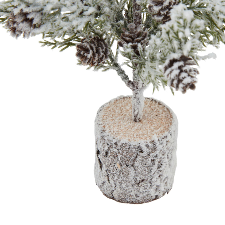 Small Snowy Fir Tree With Pinecones In Wood Log